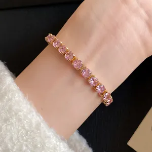 Detail of 18k gold plated bracelet with square pink cubic zirconia stones on wrist