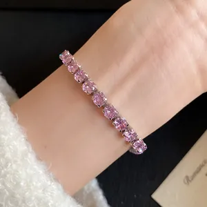 Detailed view of an elegant pink round zircon bracelet with 18k gold plating on a wrist