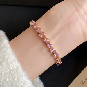 Close-up of elegant 18k gold plated bracelet with square pink zircon stones on wrist
