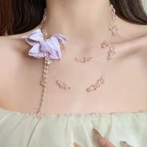 Detail of a sweet double-layered necklace with a purple fabric flower and crystals.