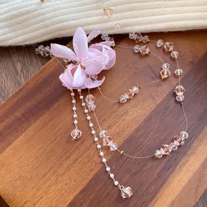 Exquisite detail of a pink fabric flower pendant necklace featuring crystal beads and pearls.