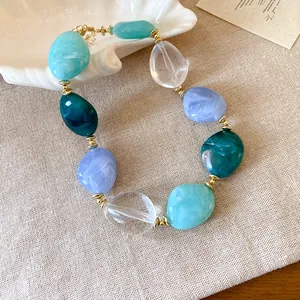 Primo piano di una collana di acrilico colorata con perle ovali marmorizzate estive