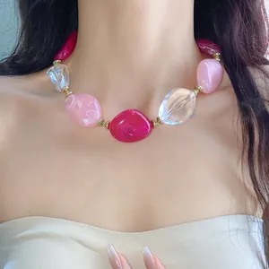 Dettaglio collana in acrilico con grandi perle ovali rosa, fucsia e trasparenti.