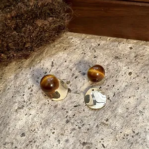Close-up of vintage resin round stud earrings with metallic gold disc detail