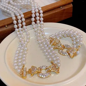 Elegante set di collana di perle multifilo con chiusura dorata e strass scintillanti