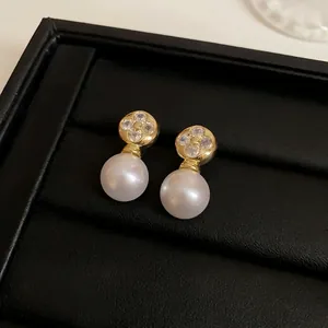 Elegant French style gold pearl stud earrings featuring a sparkling clover crystal motif