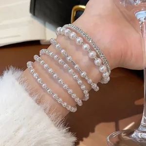 Nahaufnahme eines eleganten mehrlagigen Perlen- und Strassarmbandsets am Handgelenk