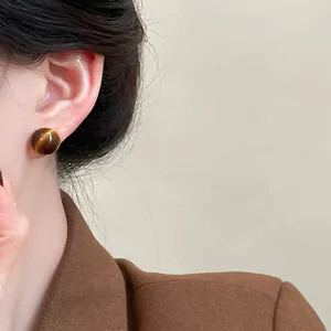 Close-up of retro brown resin ball stud earring in Maillard style worn by model