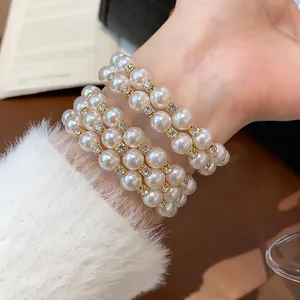 Detaillierte Ansicht eines zweilagigen Perlenarmbands mit edlem Strassbesatz am Handgelenk