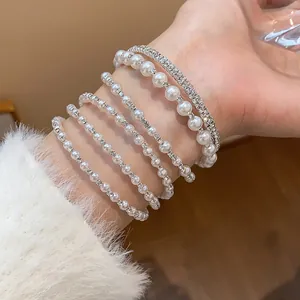 Exquisite Nahaufnahme von mehrlagigen Perlen- und Strassarmbändern am Handgelenk getragen
