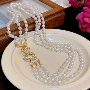 Elegante collana di perle a più fili con dettaglio centrale in oro incastonato di cristalli