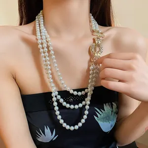 Dettaglio di una collana di perle a tre fili con lussuosa chiusura in cristallo