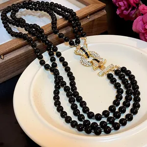 Elegante collana a più fili di perle nere con chiusura scintillante con strass