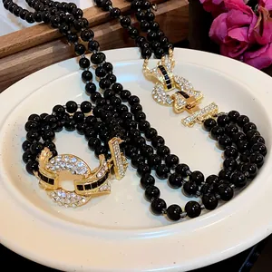 Dettaglio di un'elegante collana di perle nere multifilo stile francese con chiusura in strass