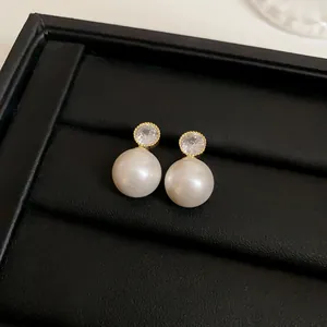 Close-up of elegant French style pearl earrings with sparkling crystal accents