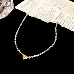 Detailweergave van een hartvormige hanger ketting met zilveren gefacetteerde kralen op zwart.