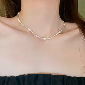 Elegante minimalistische zilveren ketting met witte parels om vrouwelijke hals, detailopname