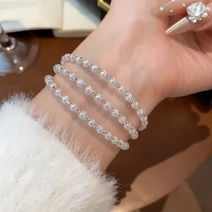 Detailansicht eines eleganten mehrlagigen Perlenarmbands mit funkelnden Strass-Zwischenstücken