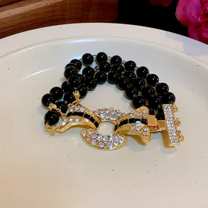 Dettaglio macro della chiusura di lusso con strass e perline nere su collana a più fili