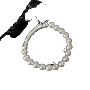Elegante bracciale di perle stile francese con elemento in tubo di metallo argentato curvo