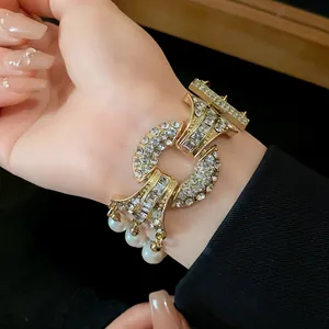 Vista dettagliata di un bracciale dorato di lusso con grandi cristalli e perle eleganti