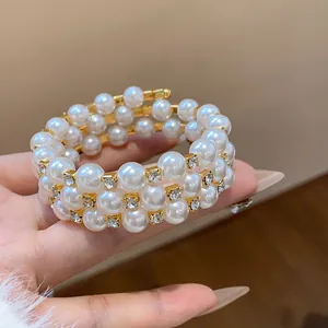 Nahaufnahme eines eleganten mehrlagigen Perlenarmbands mit glitzernden Strasssteinen