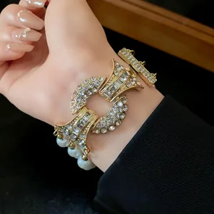 Dettaglio di una collana di lusso con perle e strass indossata con eleganza al polso