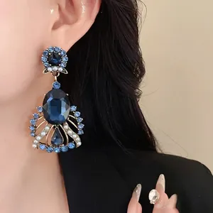 Elegant vintage drop earrings featuring blue crystals and faux pearls on an Asian model