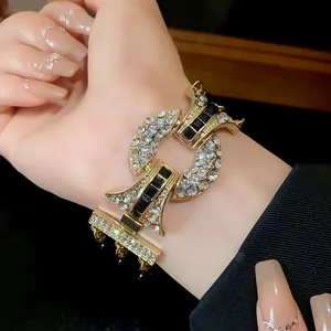 Vista macro dettagliata di un bracciale in oro con strass trasparenti e pietre nere scintillanti