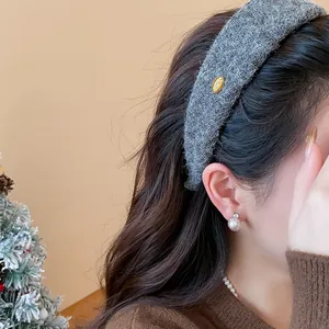 Detail of a grey textured wide headband for high top hair style on model