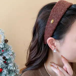 Close-up view of a brown textured flocked wide headband on a woman with dark wavy hair