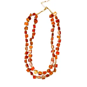 Collana vintage a doppio strato con perle di conchiglia arancioni irregolari e oro.