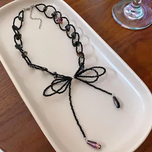 Collana con ciondolo a fiocco in stile dark minimalista con perline nere lucide.