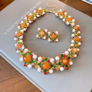 Vintage palace style jewelry set with orange stones, pearls, and multi-colored crystals.