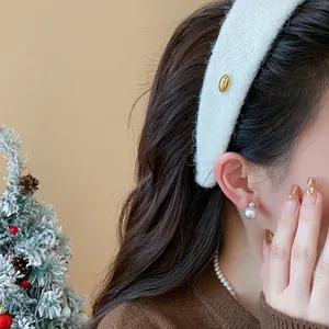Detail of white flocked wide headband on model with elegant pearl accessories