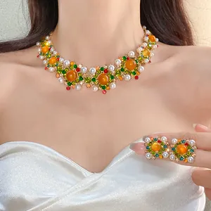 Detailed view of vintage court style jewelry set with pearls and colorful rhinestones.