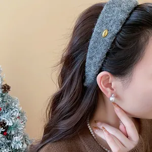 Close-up detail of grey flocked wide headband with a decorative gold Korea tag on model