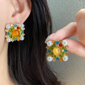 Close-up of vintage court style square earrings with colorful crystals and pearls