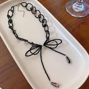 Primo piano di una collana di perline nere con ciondolo a fiocco e cristalli a goccia