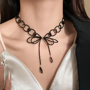 Dettaglio collana choker con fiocco di perline nere e cristalli a goccia scuri