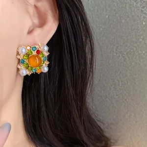 Close-up of vintage court style square earring with pearls and colorful rhinestones.