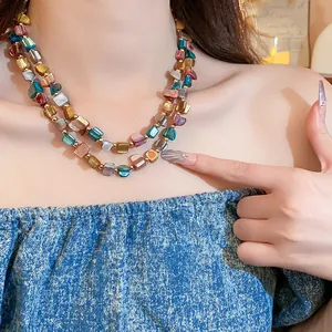 Primo piano elegante di una collana retrò a doppio strato con perle di conchiglia su modella
