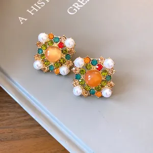 Macro view of vintage court style square earrings featuring colorful rhinestones and pearls