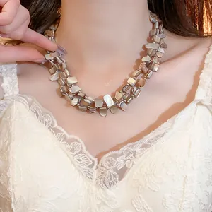 Collana a doppio strato con perle di conchiglia irregolari indossata da una modella