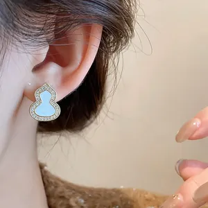 Close-up detail of an elegant zircon-encrusted gourd earring with light blue enamel inlay