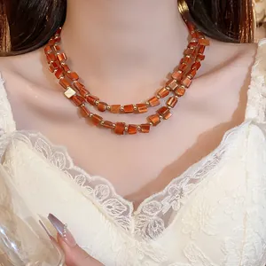 Dettaglio della collana vintage a due strati con perle di conchiglia irregolari e dorate.