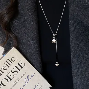 Primo piano dettagliato della collana con ciondolo a stella in argento su cappotto scuro