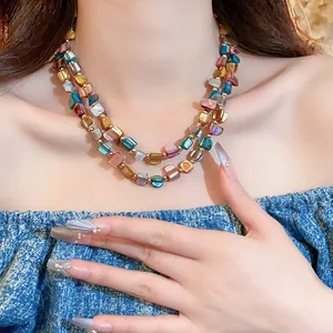 Primo piano di una collana retrò a doppio strato con perle di conchiglia irregolari su una modella