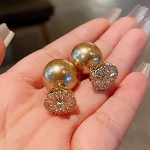 Close-up view of elegant gold-plated zircon pearl earrings featuring a champagne champagne shine.