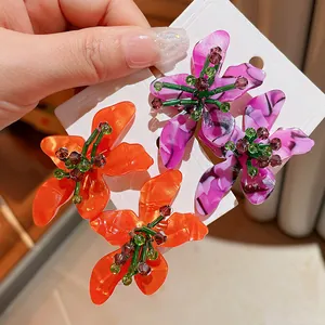 Close-up of vibrant floral acetate earrings with crystal bead details